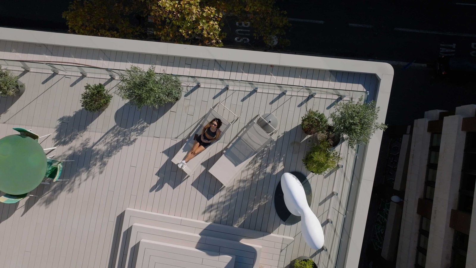 Toma aérea con dron de una mujer relajándose en una terraza